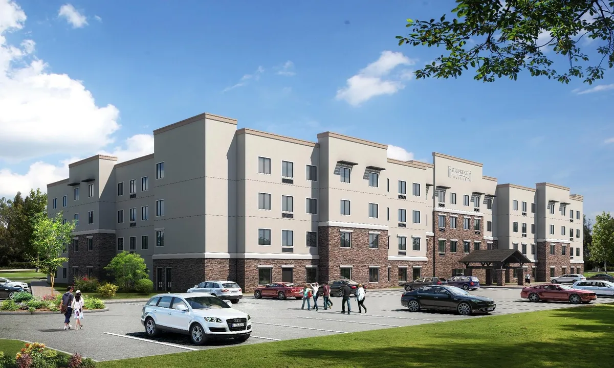 This exterior image features the property's main entrance, surrounded by manicured landscaping and a visible parking area. The scene feels welcoming and accessible, highlighting both the curb appeal and the convenience of parking right at the property.