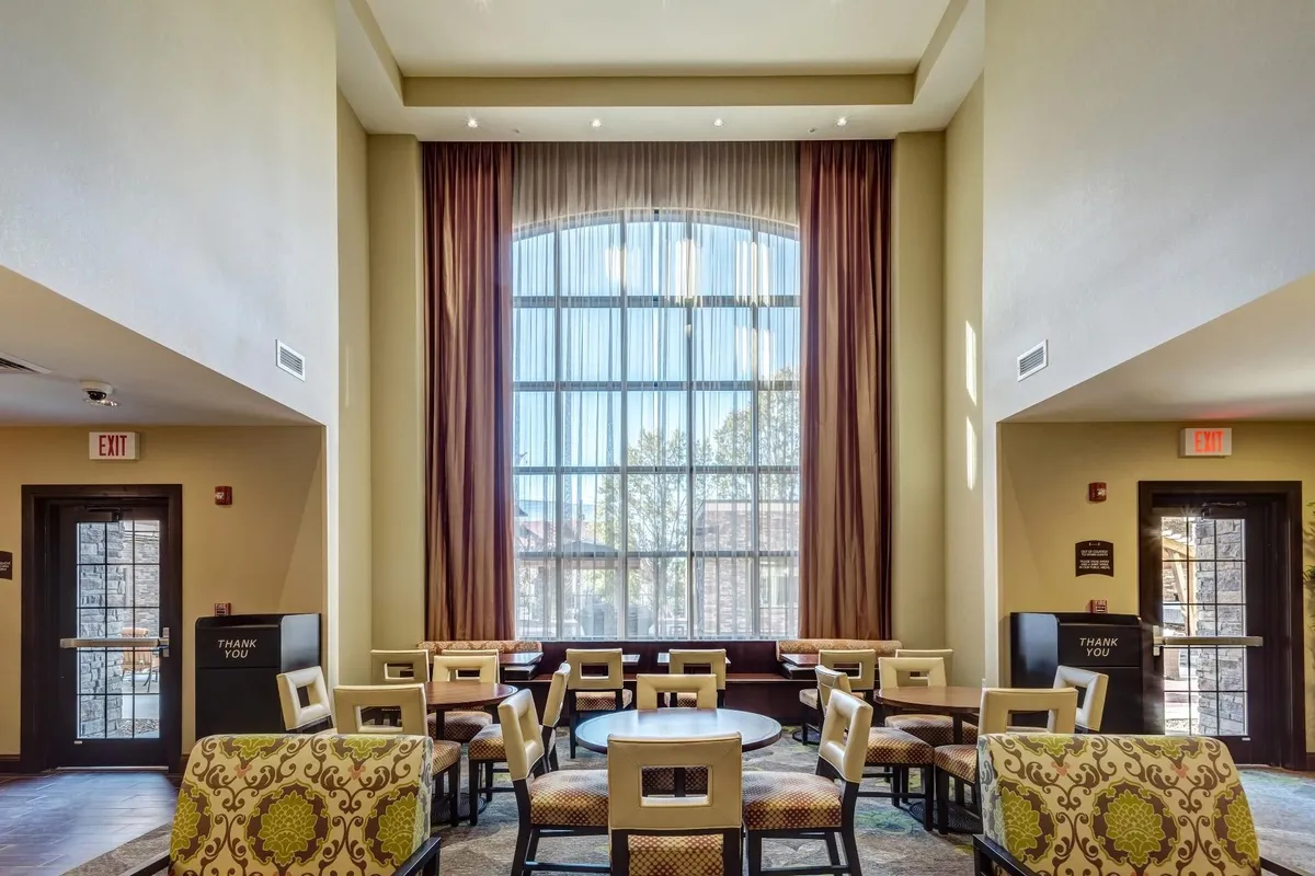 A bright, cozy living area with a large arched window, plush seating, and decorative touches. The space exudes comfort and is ideal for relaxing, reading, or spending time with loved ones.